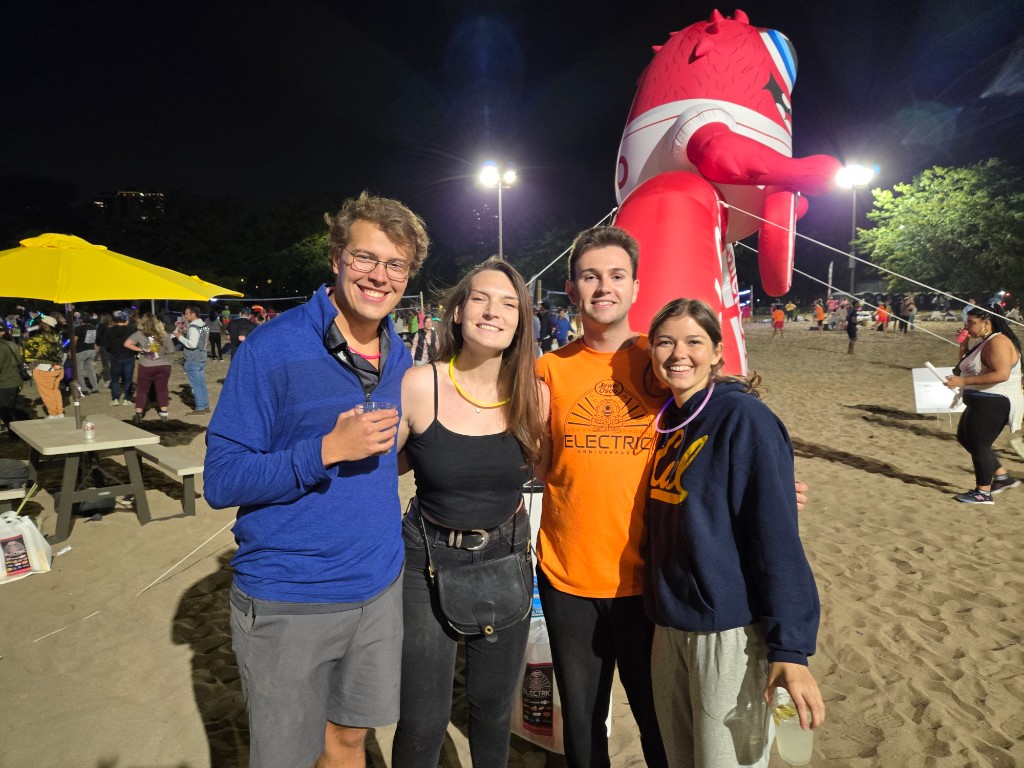 Logan Riebel with friends at a beach event at night